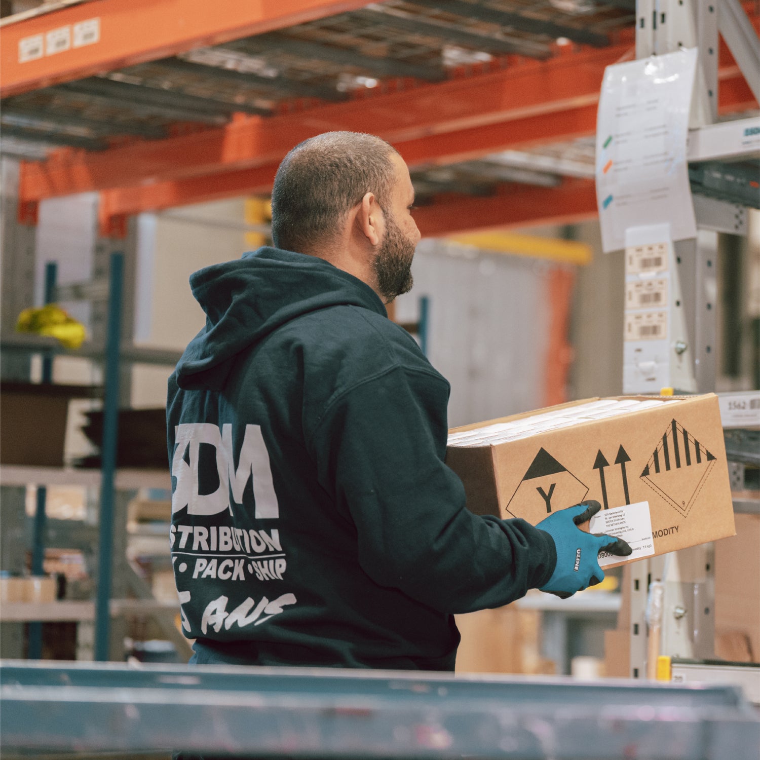 3DM Warehouse Worker loading box onto caseflow for picking efficiency